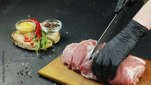 closeup view of chef man hands in gloves cutting fresh raw meat on chopping board cooking dish protein diet spices chilli pepper spices mustard souce meal cut khife preparation tenderloin beef steak photo