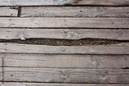 Closeup fragment of cracked wood texture with nails and holes