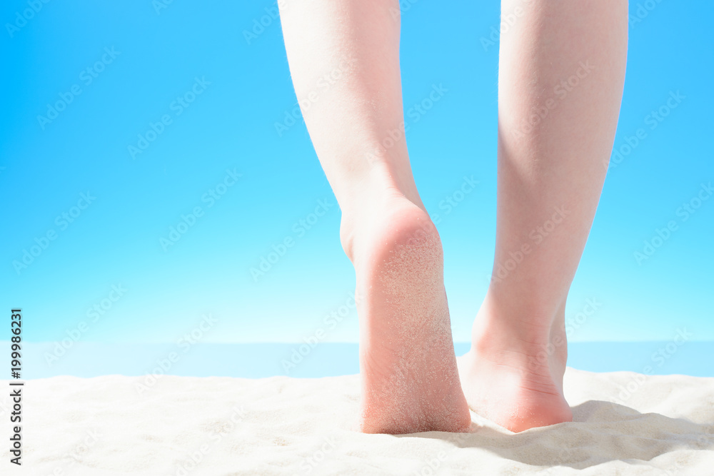 Little girl walks on the sandy beach, part of the body Little girl walks on the sandy beach, part of the body