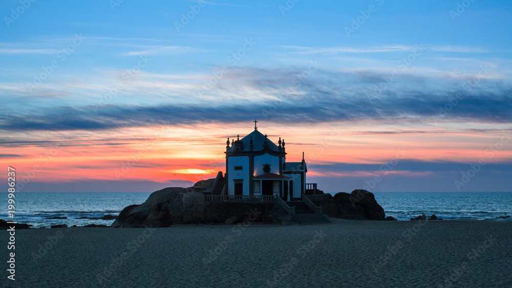 Chapel Senhor da Pedra at sunset, Miramar Beach in Porto, Portugal.