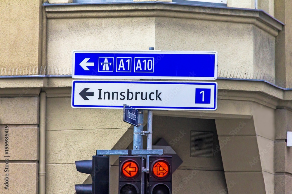 Obraz premium A traffic light with arrows and an exit sign for 1 and 10 highways in the direction of Innsbruck. Salzburg. Austria