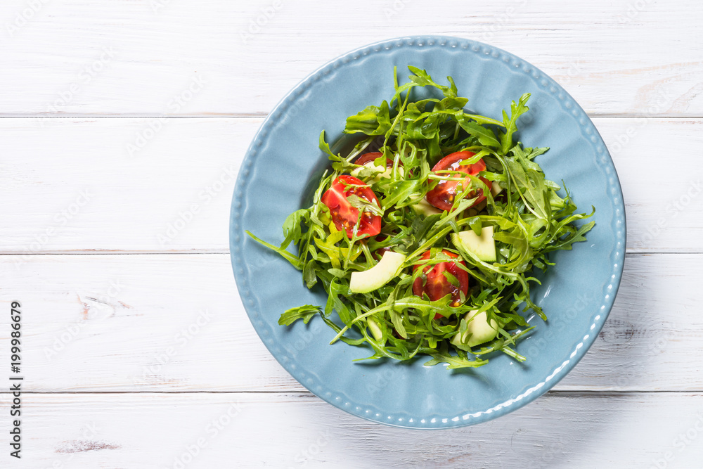Healthy vegan salad from arugula, avocado and tomatoes. Healthy vegan salad from arugula, avocado and tomatoes.
