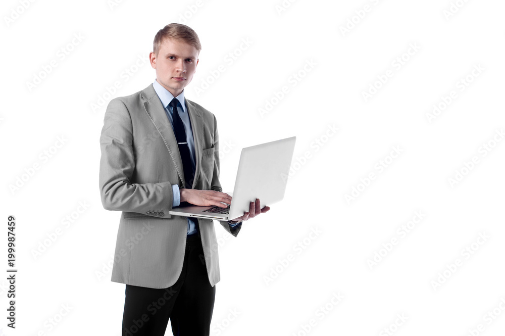 Young businessman with laptop in hand standing on white isolated background and looking at you Young businessman with laptop in hand standing on white isolated background and looking at you