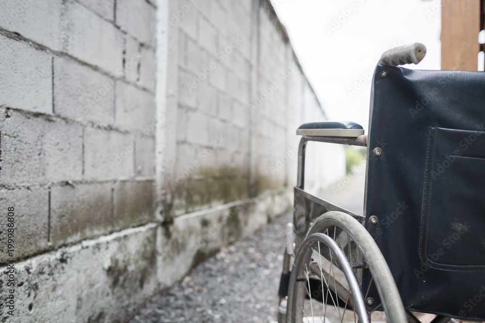 Close up wheelchair outdoor with concrete wall.