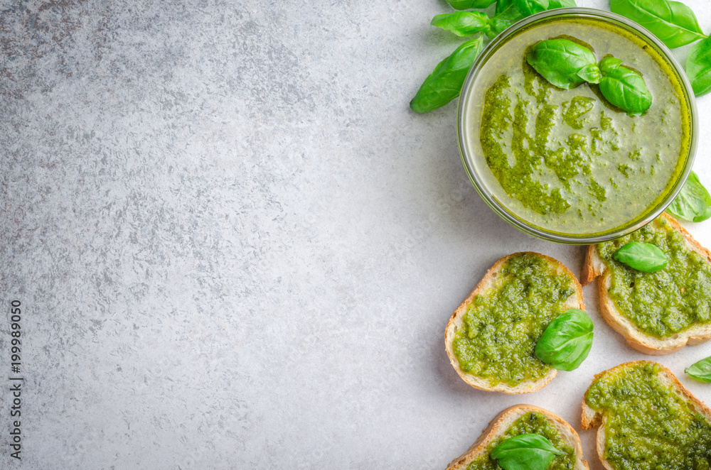 Obraz premium Pesto sauce and sliced bread on a stone table