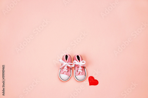 Baby sneakers on pink background