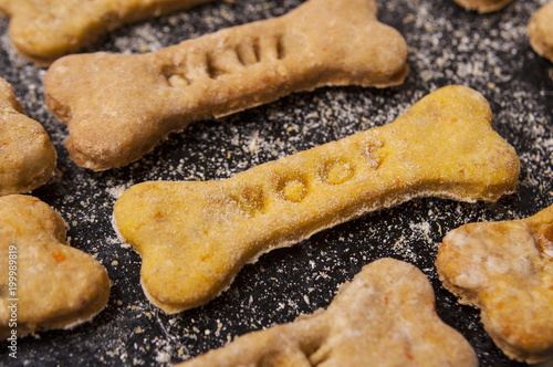 Homemade oatmeal dog treats with carrots on black background