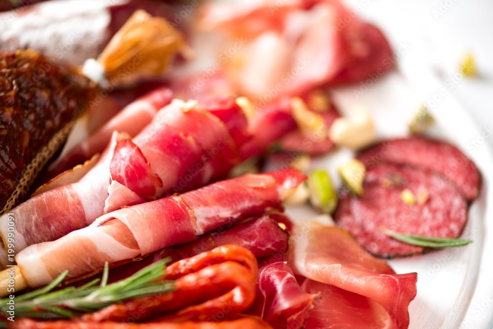 Cold smoked meat plate. Traditional italian antipasto, cutting board with salami, prosciutto, ham, pork chops, olives on grey background. Top view, copy space, flat lay Cold smoked meat plate. Traditional italian antipasto, cutting board with salami, prosciutto, ham, pork chops, olives on grey background. Top view, copy space, flat lay