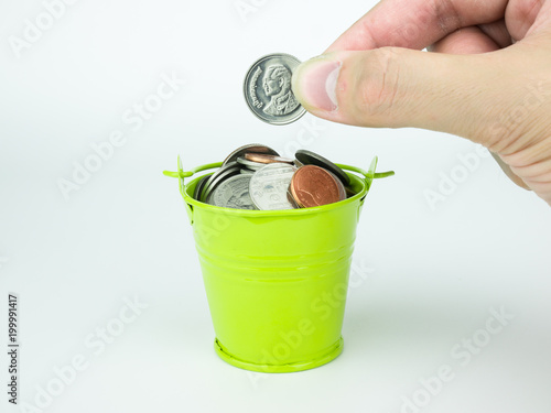 Saving Money coins in green bucket on white background, Business concept photo