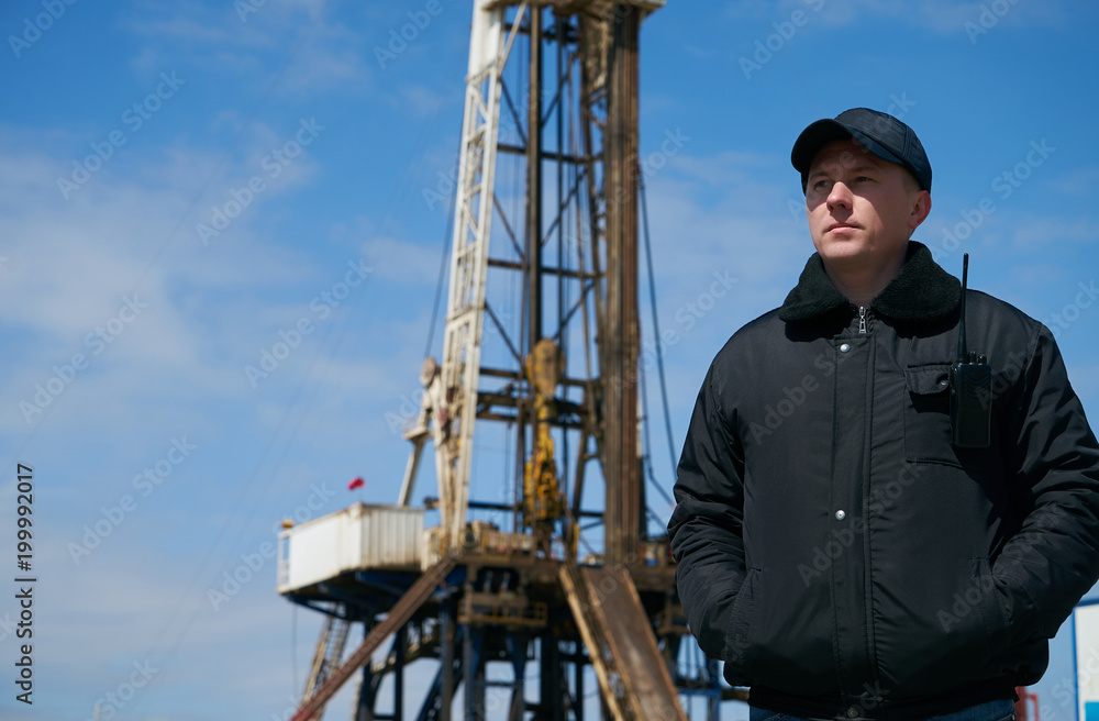 Oil Rig Protection Security guard with walkie talkie, controlling outdoor oil drilling rig ...
