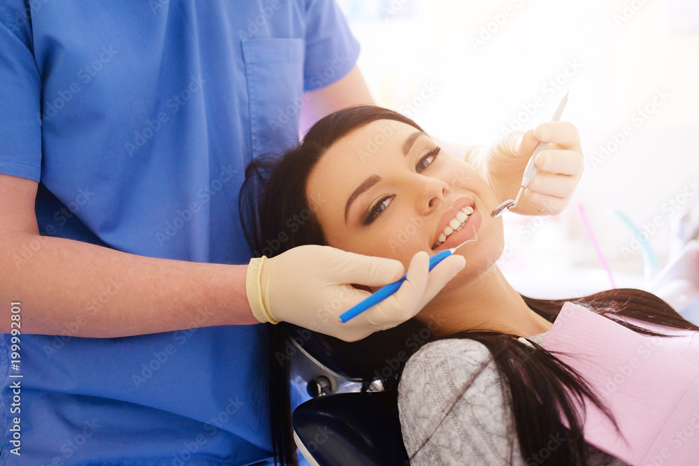 Naklejka premium Beauty brunette having teeth examined at dentists.