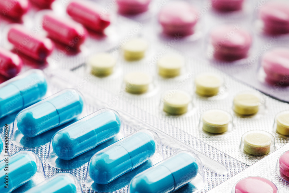 Heap of medical pills in white, blue and other colors. Pills in plastic package. Concept of healthcare and medicine. Heap of medical pills in white, blue and other colors. Pills in plastic package. Concept of healthcare and medicine.