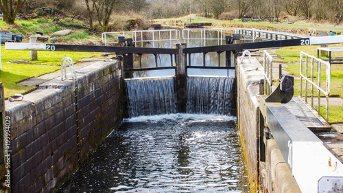 Quadro em tela Water flowing over a closed canal lock gate.