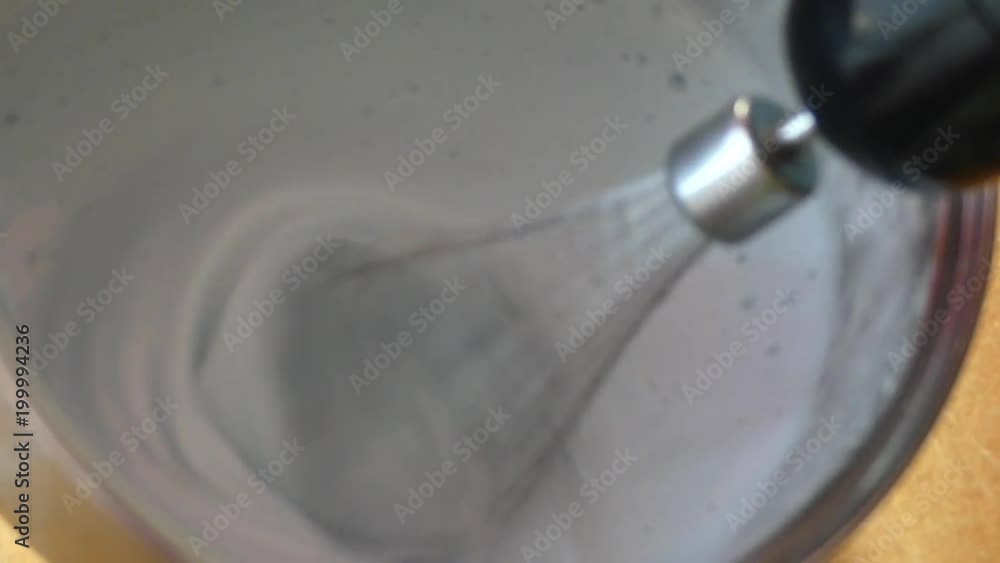 The process of forming a lush cream custard topping in a metal bowl, which stands in automatic mixer. The process of forming a lush cream custard topping in a metal bowl, which stands in automatic mixer.