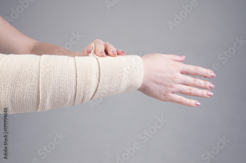Fractures and dislocations concept. Female hand in a white bandage. A useful preparation for the painful palm of a person's hand.