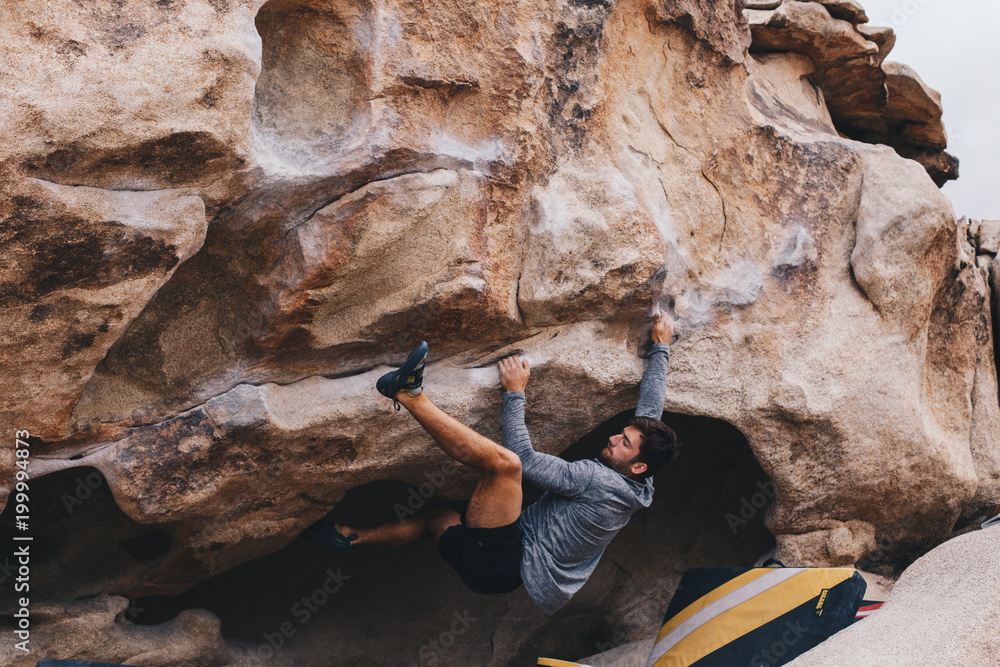 Φωτογραφία Man Bouldering outside with a heel hook
