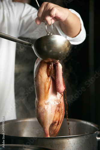 Chef preparing of Peking Roast Duck in the kitchen of restaurant. Peking Duck is a famous duck dish from Beijing