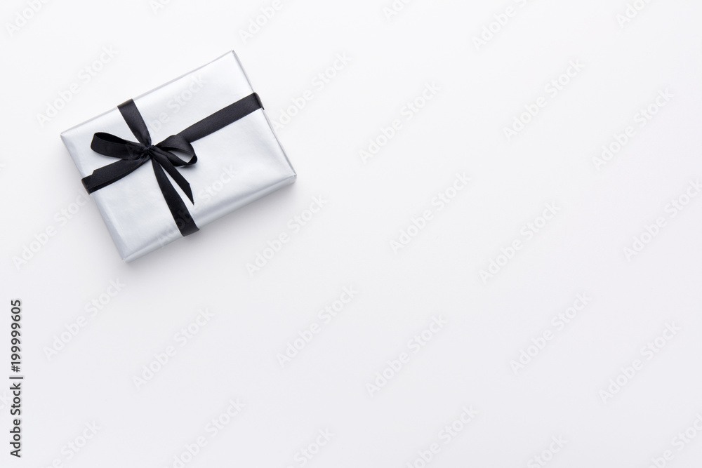 Hands holding wrapped gift box with colored ribbon as a present for Christmas, new year, mother's day, anniversary, birthday, party, on white background, top view. Present for a colleague at work. Hands holding wrapped gift box with colored ribbon as a present for Christmas, new year, mother's day, anniversary, birthday, party, on white background, top view. Present for a colleague at work.