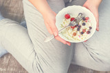 Full girl holding a plate of cottage cheese. Healthy eating concept. Cottage cheese with berries. Girl in home clothes. Proper nutrition. Diet. Health. Small depth of field. Toned image.