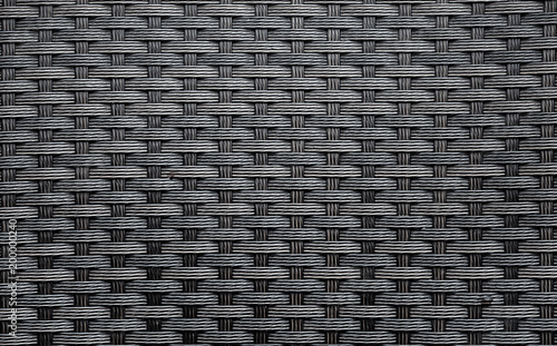 Black artificial rattan pattern. Background of basket structure close-up. Furniture backdrop photo