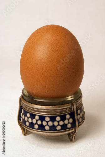 One soft-boiled egg on a beautiful stand eggcup English breakfast close-up of a white background photo