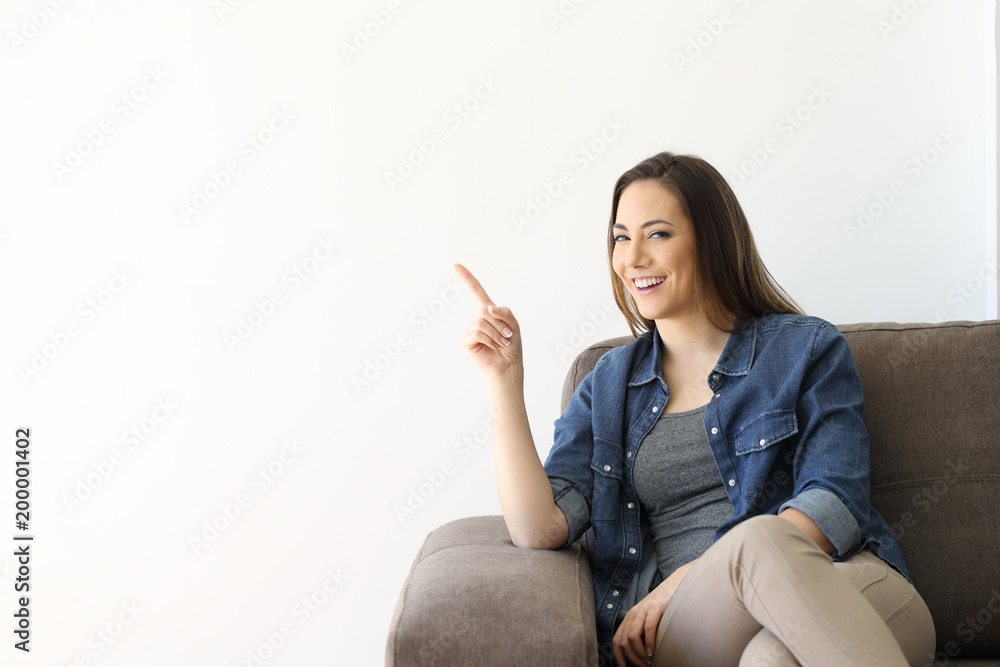 Happy woman looking at camera pointing at side Happy woman looking at camera pointing at side
