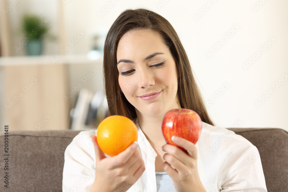 Girl deciding between two fruits Girl deciding between two fruits