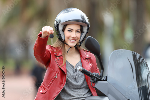 Biker showing motorbike keys on her scooter