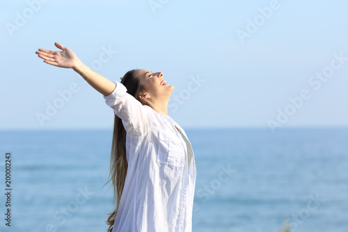 Satisfied woman breathing on the beach