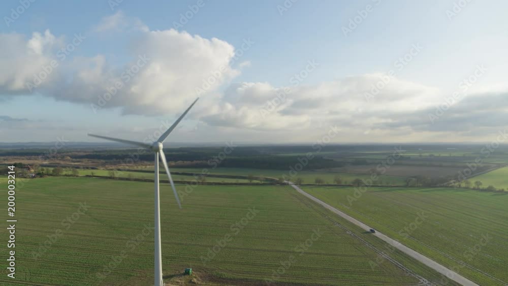 Aerial of lone windmill generating green energy with grassy plains in background Aerial of lone windmill generating green energy with grassy plains in background