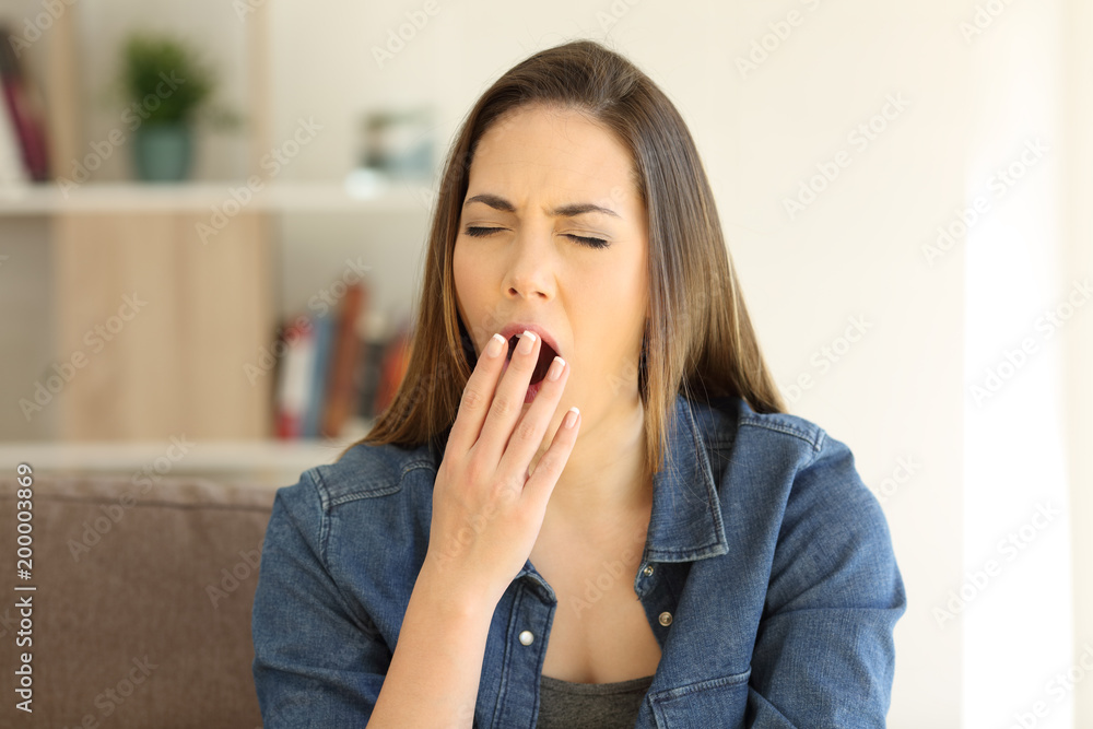 Tired woman yawning covering mouth Tired woman yawning covering mouth
