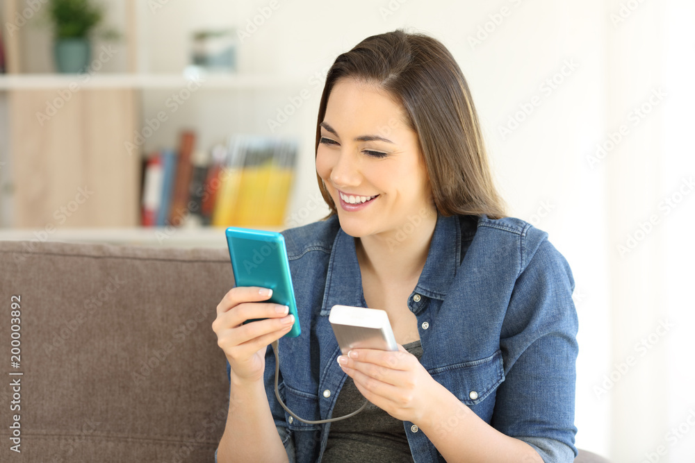 Woman charging phone with a portable charger Woman charging phone with a portable charger