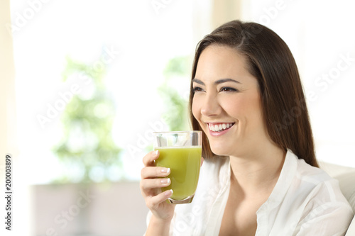 Woman drinking a vegetable juice looking away
