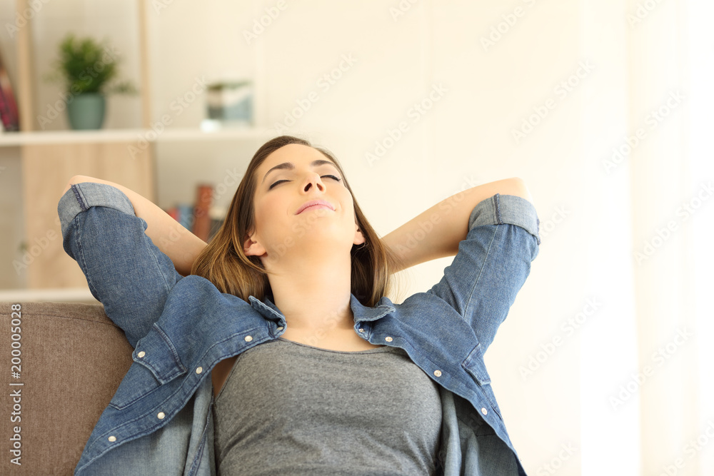 Woman relaxing sitting on a couch at home Woman relaxing sitting on a couch at home