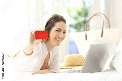 Woman showing a credit card in summer vacations