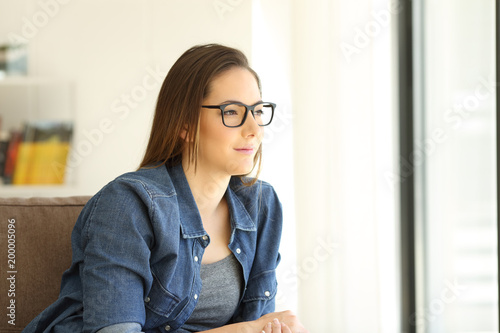 Woman wearing eyeglasses looking through a window