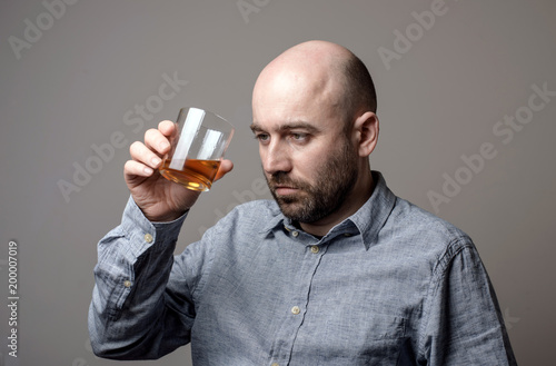 depressed bald man with alcohol glass © Vitaliy Hrabar