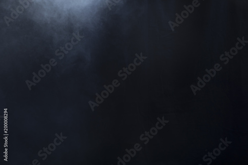 Smoke clouds create fog on left side of black background