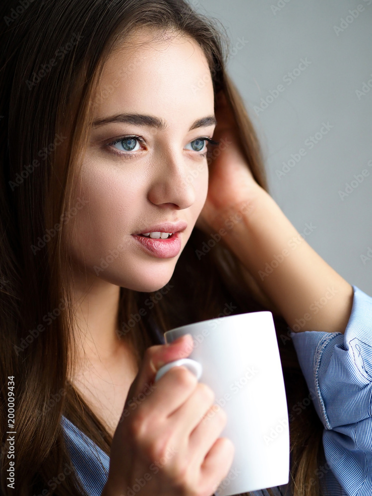 Beautiful young woman hold in arms white cup Beautiful young woman hold in arms white cup