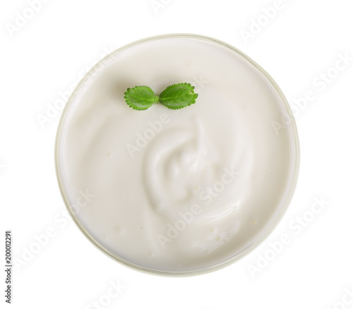 Bowl of yogurt with mint leaf isolated on white background top view