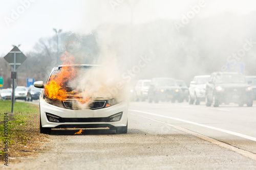 Burning car on fire on a highway road accident