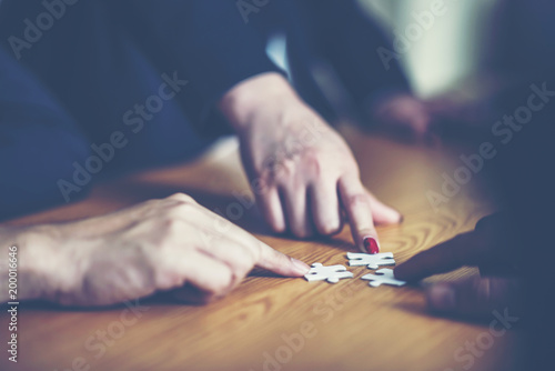 hands trying to connect couple puzzle piece with background, one part of whole. symbol of association and connection. business strategy.