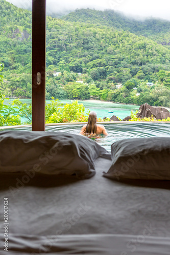 Paradise beach of Seychelles. view of woman's back admiring the sea.