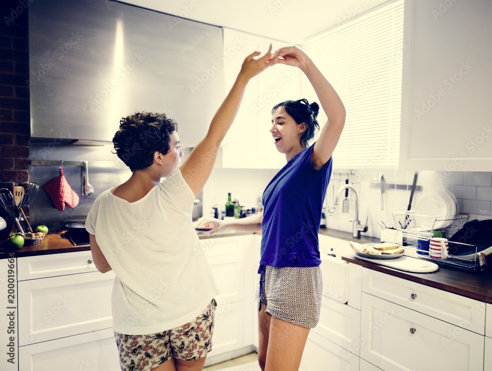 Lesbian couple dancing in the kitchen Lesbian couple dancing in the kitchen