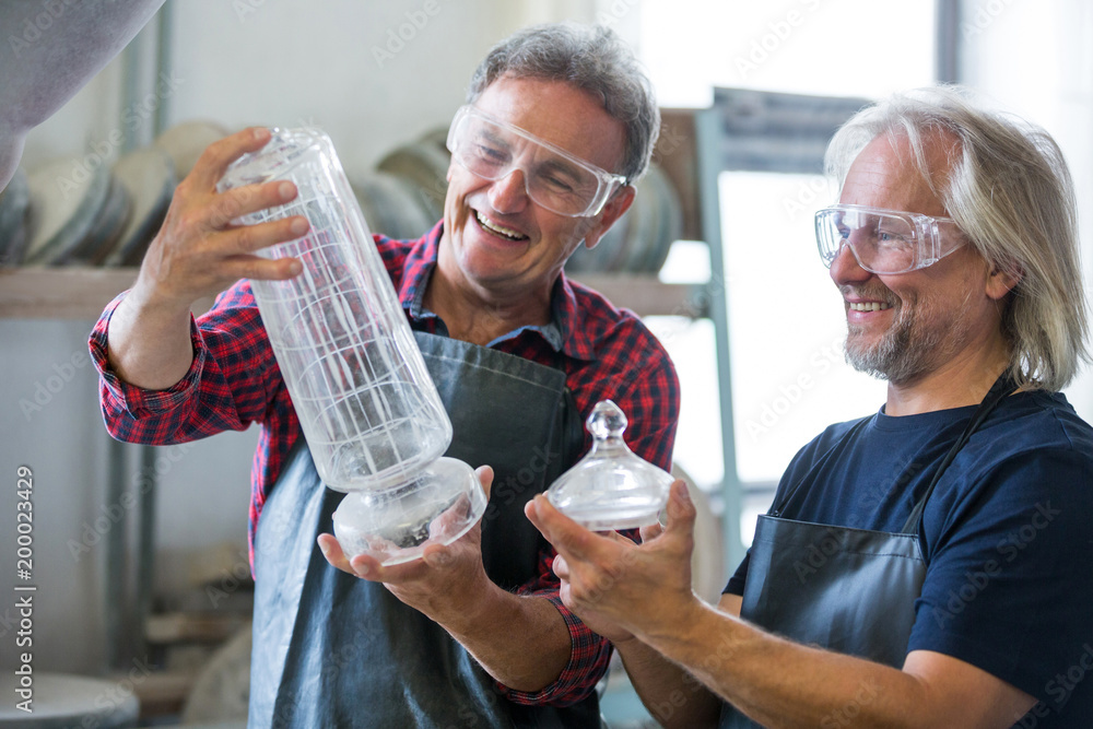Glassblower and a colleague looking glassware