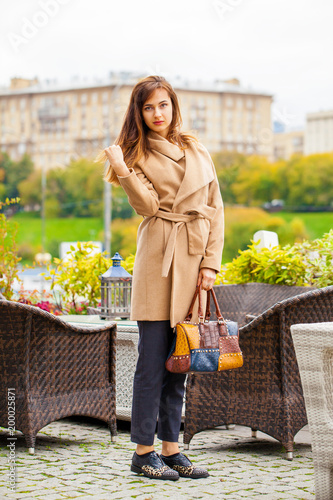 Portrait of a young beautiful woman in beige coat