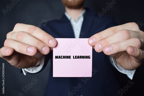 A businessman shows an inscription:MACHINE LEARNING