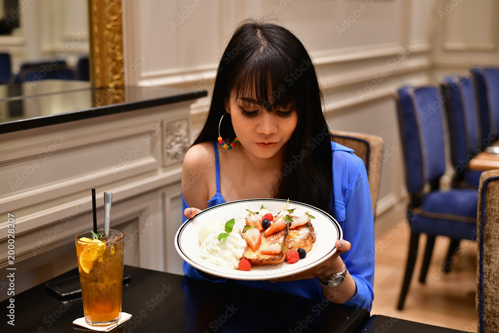 Restaurant Concept. Asian women eating in restaurant. Asian women are happy to eat. Asian women relax in a restaurant. In the restaurant, Asian women are smiling happily. Restaurant Concept. Asian women eating in restaurant. Asian women are happy to eat. Asian women relax in a restaurant. In the restaurant, Asian women are smiling happily.