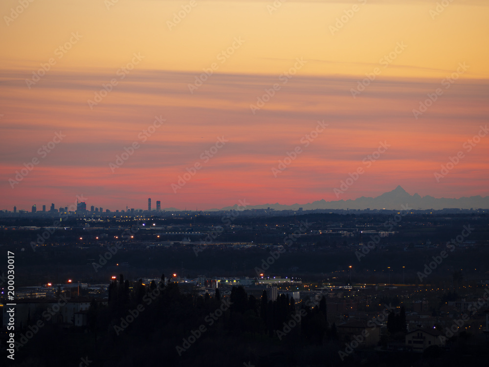 The Monviso and the skyscrapers of Milan from the walls of Bergamo during the sunset The Monviso and the skyscrapers of Milan from the walls of Bergamo during the sunset