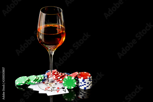 Wineglass of wine and poker cards with colored chips